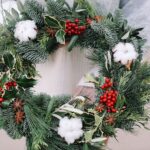 Christmas decorations. Christmas wreath. Florist making Christmas wreath. View of female hands holding a wreath.
