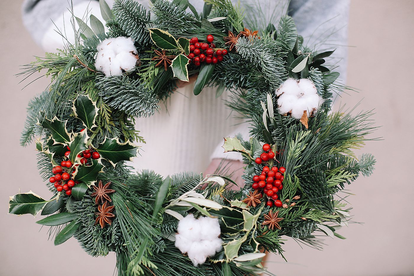 Christmas decorations. Christmas wreath. Florist making Christmas wreath. View of female hands holding a wreath.